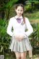 A young woman in a school uniform posing for a picture.