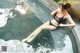 A woman in a black and red bikini sitting in a pool.