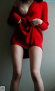 A woman in a red sweater is posing for a picture.