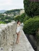 A woman standing on a stone wall next to a river.