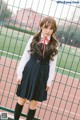 A young woman in a school uniform posing for a picture.