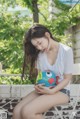 A woman sitting on a chair holding a toy fish.