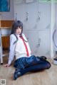 A woman in a school uniform sitting on the floor.