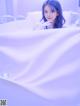 A young woman sitting in a bathtub with bubbles in it.