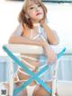 A woman in a white lingerie sitting on a chair.