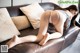 A woman laying on top of a brown couch.