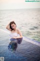 A woman in a white bathing suit sitting in a swimming pool.