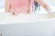 A woman in a pink shirt is taking a bath.