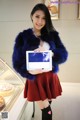 A woman in a fur coat holding a tablet computer.