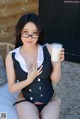 A woman in a black and white dress holding a glass of milk.