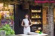 A woman standing in front of a counter in a restaurant.